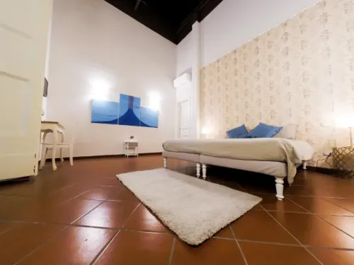 566panoramica-camera-letto-tv-quadri-domusdonnaregina-decumani